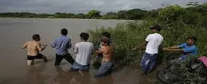 Migrantes hondureños desafían a la muerte al cruzar un río, ubicado en la frontera de El Salvador