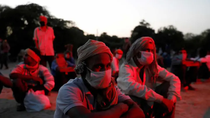 Empleados y personas sin hogar con mascarilla en Delhi, la India