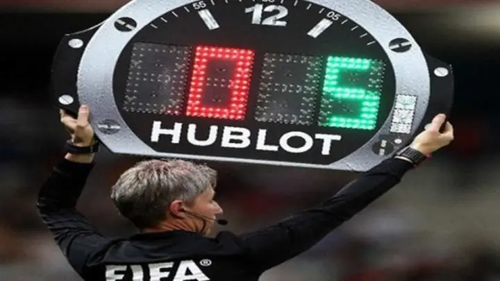 Arbitro anuncia cambio de jugador durante un partido de fútbol