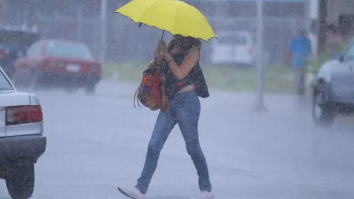 Joven cruzando la carretera durante la temporada de invierno en Managua 