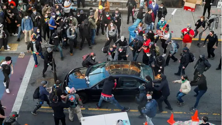 Un hombre trata de abrir el coche de una persona que lo dirigió hacia una multitud durante las protestas en Seattle, EE.UU., el 7 de junio de 2020
