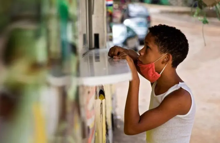Niño comprando en una pulpería comida 