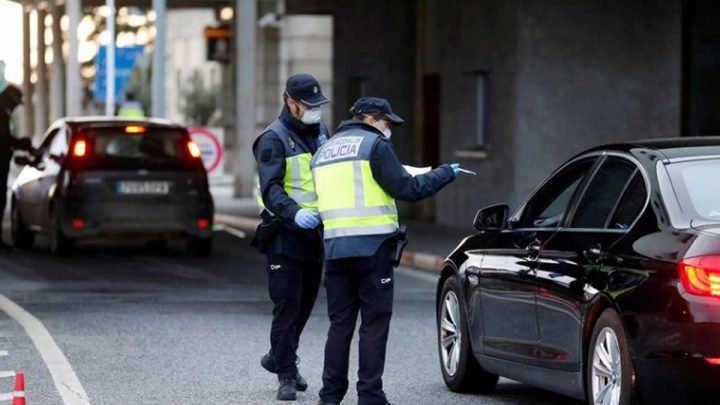 Un policía revisa un coche en la frontera entre Portugal y España, siguiendo una orden del gobierno español de establecer controles en sus fronteras terrestres sobre el coronavirus.