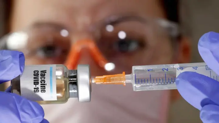Médico extrayendo liquido para vacuna.