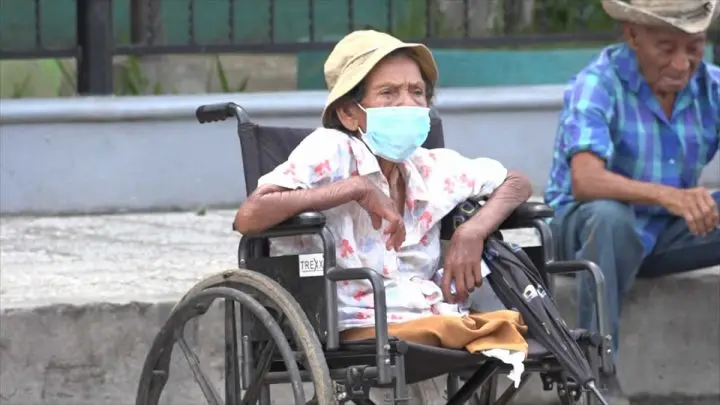 Señora con discapacidad sentada en una silla de ruedas.