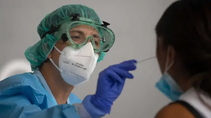 Un sanitario recoge una muestra de una mujer en un centro de pruebas temporal para el Sars-Cov-2 en Azpeitia