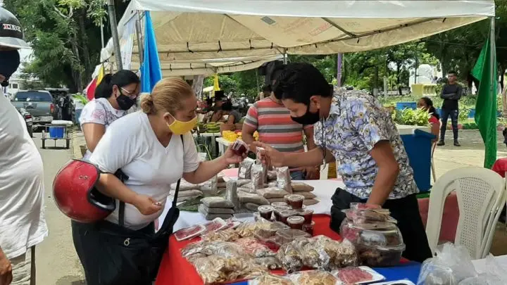Mujer comprando "dulces típicos" en feria de Masaya. 