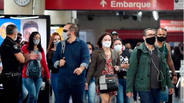 Personas caminando con mascarilla en una estación.