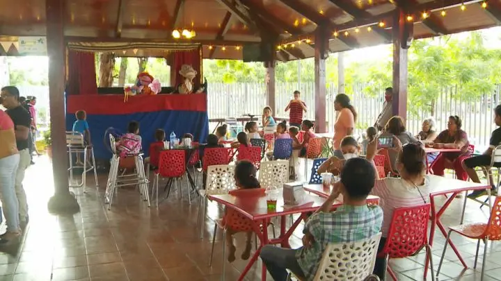 Niños y adultos disfrutando del show de títeres