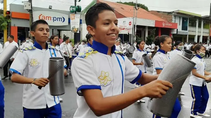Estudiante toca instrumento musical en banda rítmica. 