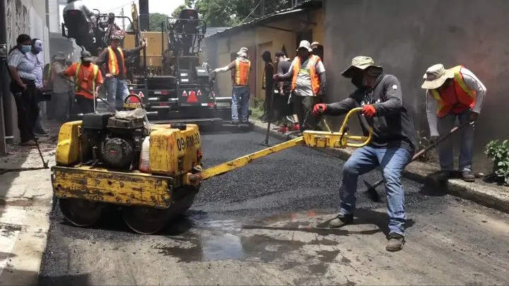 Hombres operando maquinas en construcción de calles.