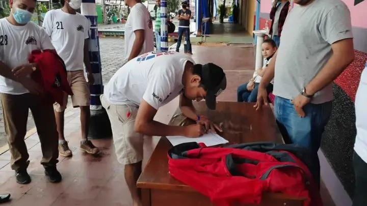 Persona firmando un documento.