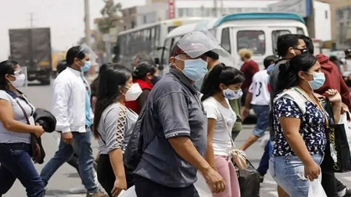 Personas con mascarillas caminando por una avenida