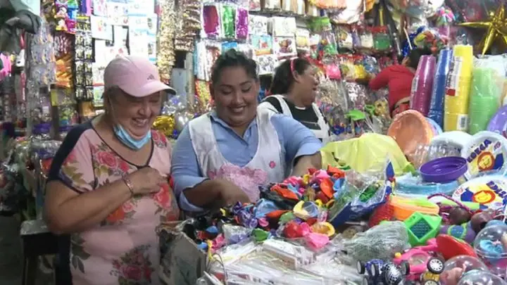 Comprador y comerciante sonrientes en el mercado Roberto Huembes. 