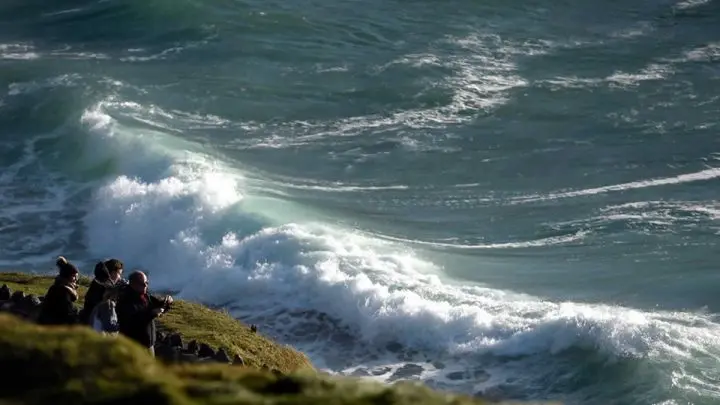La gente contempla el océano Atlántico desde Ventry, Irlanda, el 27 de diciembre de 2016.