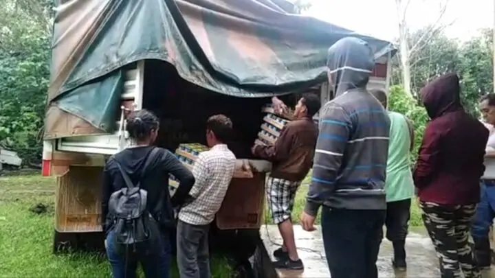 Personas descargando provisiones en albergue. 