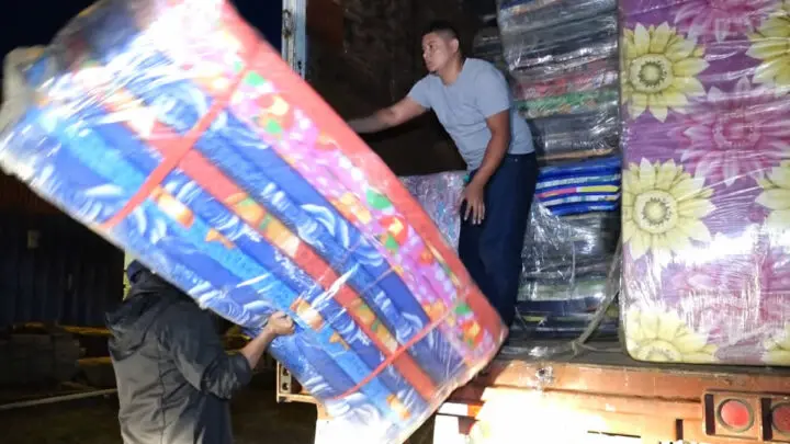 Hombres preparan cargamento de víveres.
