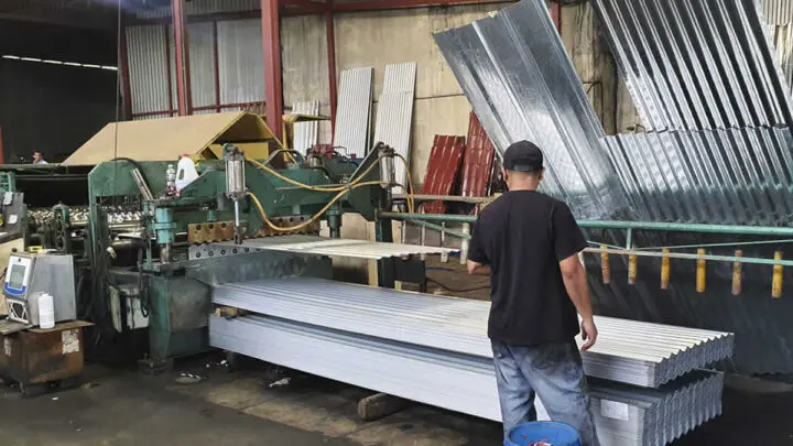 Hombre trabajando en maquinarias de láminas de zinc.