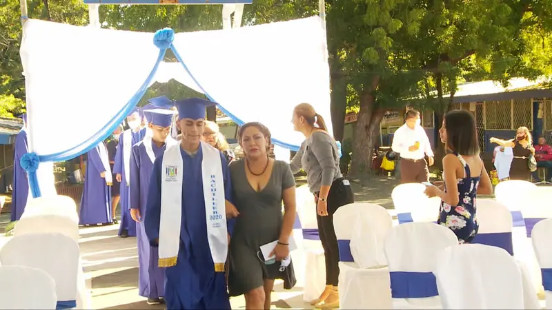 Alumno se promociona, de la mano de su mamá.