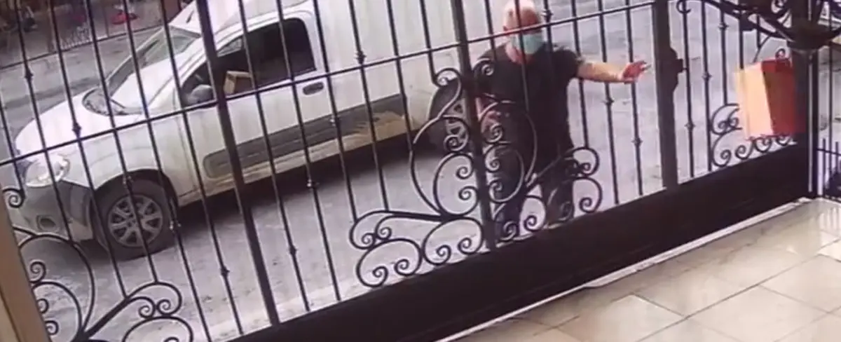 Un repartidor es grabado lanzando por los aires un portátil a través de una verja en México