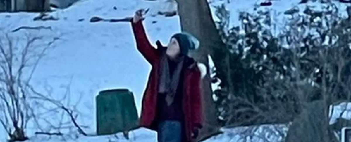 Una mujer se toma una foto parada sobre un coche mientras se hunde